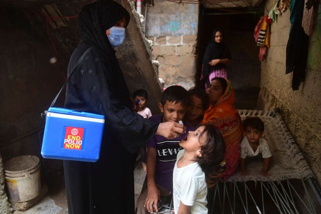 A health worker administers oral polio vaccine drops to a child during a door-to-door campaign in Karachi, Pakistan, June 27, 2022.